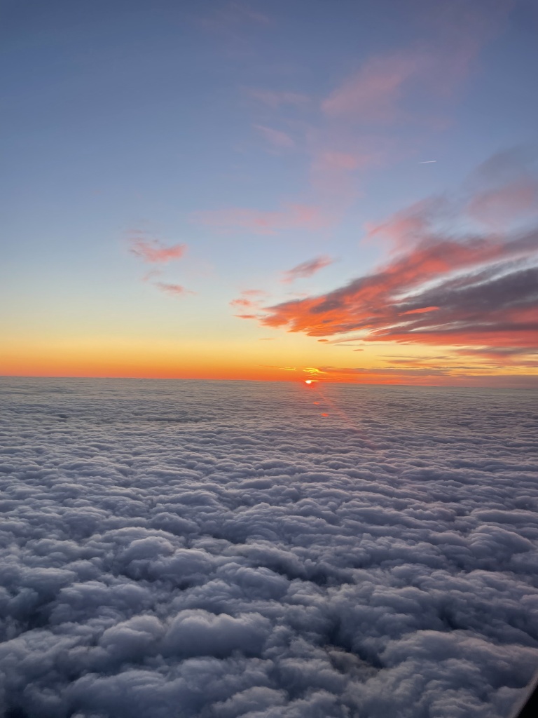 View of the sea of clouds during sunset, taken from a plane window above London