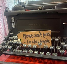 Old and worn typewriter with a tag between the keys that writes "Please don't touch - I'm old & fragile", taken in the W. Armstrong vintage shop in Edinburgh.